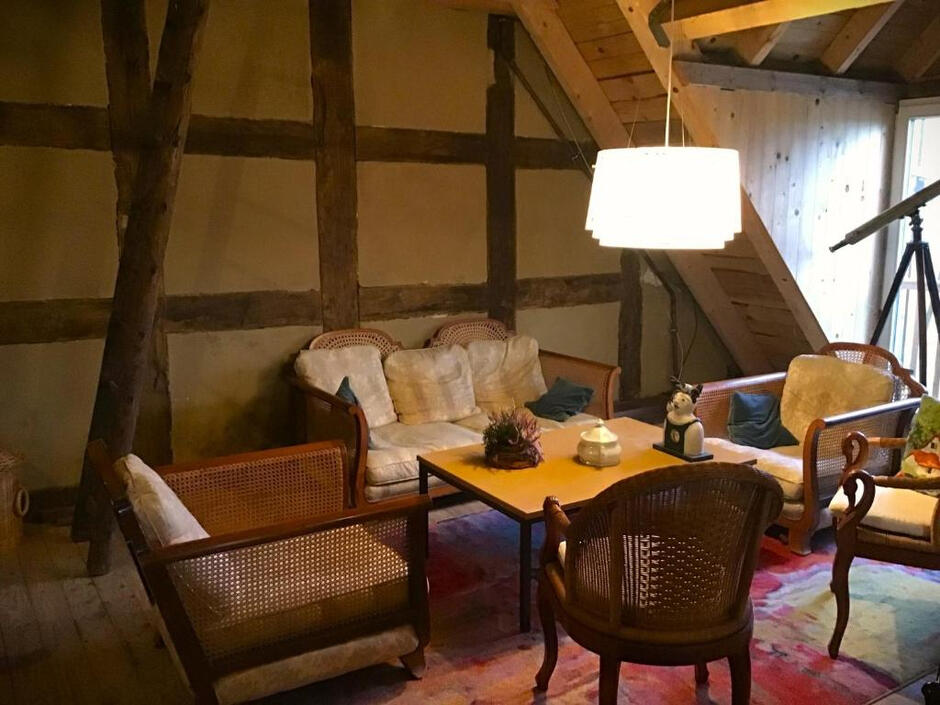 Gemütlicher Aufenthaltsbereich Stilvoll eingerichteter Aufenthaltsbereich mit historischen Fachwerkbalken, bequemen Sitzmöbeln und besonderem Mühlencharme.