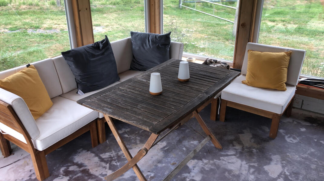 Gemütliche Terrasse mit Seeblick Überdachte Sitzecke mit gemütlichen Loungemöbeln und Blick ins Grüne – ideal zum Entspannen an der Bruchmühle.